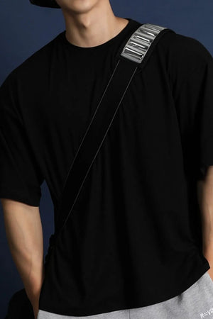 Black oversized crew neck t-shirt with a modern silhouette and silver detail on strap.