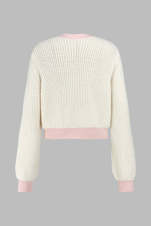 Cream acrylic cropped knit cardigan with contrast pink trim and cuffs.