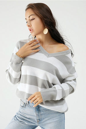 Gray and white striped V-neck relaxed knit sweater with ribbed cuffs and hem.