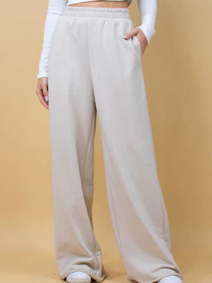Beige wide-leg lounge pants with pockets and elastic waistband.