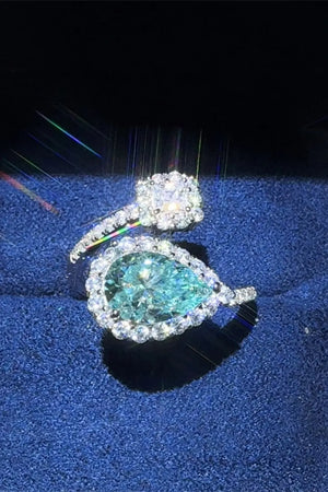 Bypass ring with pear-cut turquoise moissanite and diamond halo.