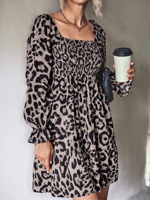 Smocked bodice leopard print mini dress with square neckline and long sleeves.