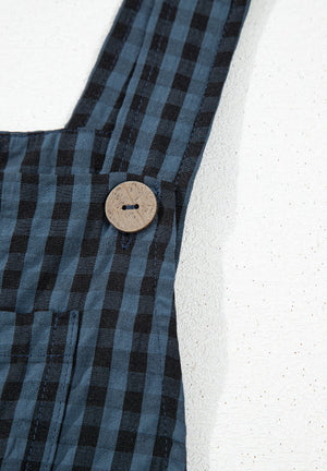 Dark blue gingham overalls with a wooden button detail on the strap.