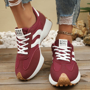 Red lace up round toe sneakers with white stripes and chunky sole