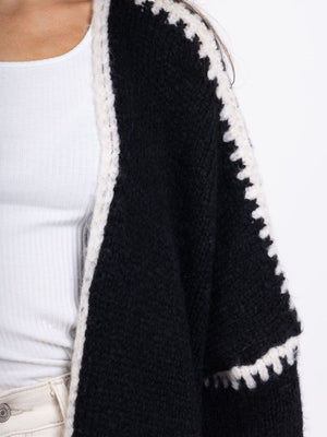 Black oversized knit cardigan with white contrast stitching detail