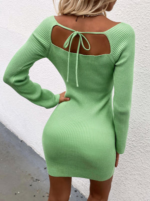 Green ribbed knit mini dress with long sleeves and a back tie detail.