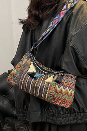Geometric embroidered shoulder bag with tassels and colorful patterned strap