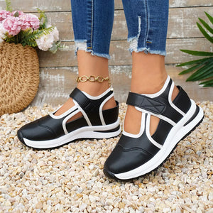Black Mary Jane sneakers with white contrast trim and cutouts, featuring hook-and-loop straps.