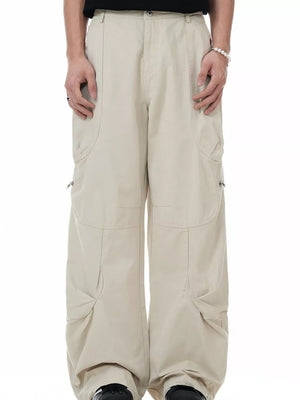 Men's beige cargo pants with multiple pockets and zipper details.