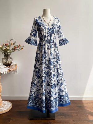 Maxi dress with blue floral print, V-neck, drawstring waist, and lace-trimmed bell sleeves.