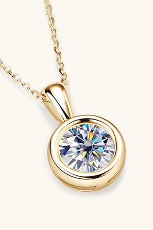Gold solitaire bezel pendant necklace with a round-cut clear stone.