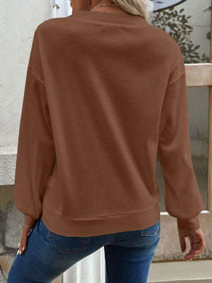 Caramel waffle knit button-down cardigan with long sleeves and a crew neckline.