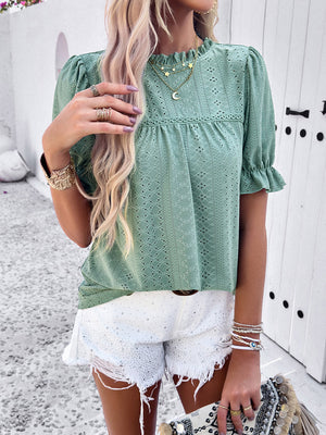 Light green eyelet puff sleeve blouse with ruffled neckline and cuffs.