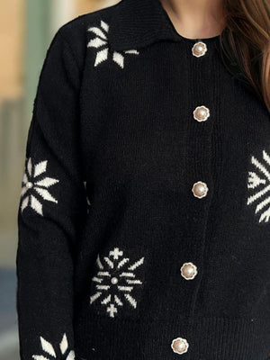 Black acrylic knit cardigan with white snowflake pattern and pearl button details.