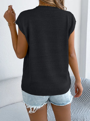 Black cable knit sweater vest with cap sleeves and a crew neck.