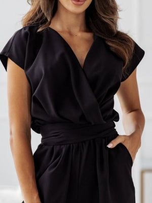 Black draped wrap-front wide-leg jumpsuit with short sleeves and a tie waist.