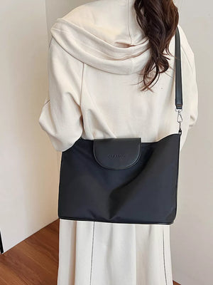 Chic canvas hobo crossbody bag in black with leather flap detail.