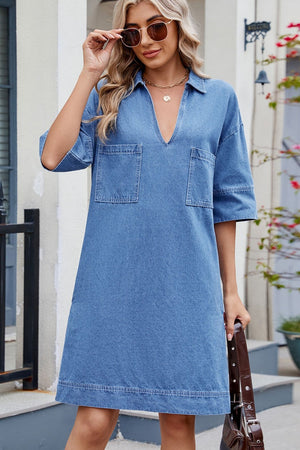 Collared denim mini dress in medium wash with two chest pockets and V-neck.