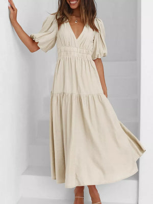 Cream midi dress with puff sleeves, V-neck, smocked waist, and tiered skirt.