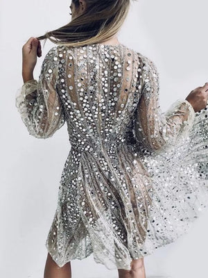 Silver sequin mini dress with balloon sleeves and a-line cut, featuring a sheer overlay.