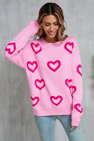 Fuchsia pink acrylic knit pullover sweater with allover heart intarsia pattern.