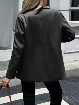 Chic lapel blazer in black with buttoned front and practical pockets, shown from the back.
