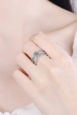 Silver pavé-set crossover engagement ring with a round-cut center stone.
