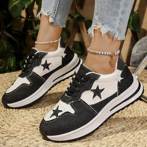 Black and white lace-up sneakers with star embellishments and a chunky sole.