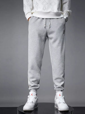Light gray cotton joggers with drawstring and cuffed hem.