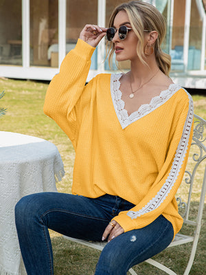 Yellow waffle knit v-neck top with white lace trim on neckline and sleeves.