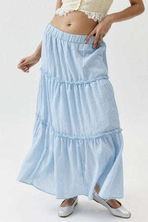 Tiered cotton maxi skirt in light blue with ruffled tiers and an elastic waistband.