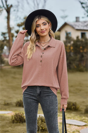 Textured knit polo shirt in dusty pink with button detail and long sleeves.