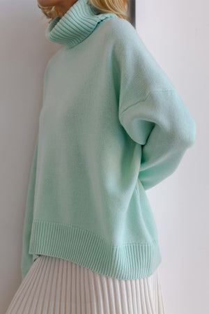 Oversized pastel blue cashmere turtleneck sweater with ribbed cuffs and hem.