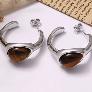 Silver sculptural hoop earrings with tiger's eye stone detail