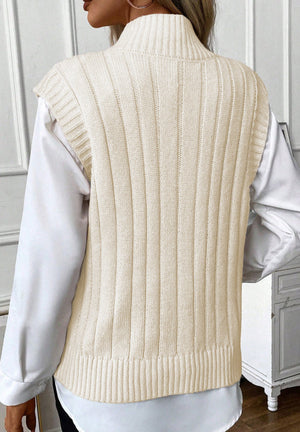 Ivory cable knit mock neck vest with ribbed texture, styled over a white shirt.