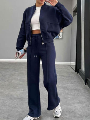 Dark blue bomber jacket and wide-leg tracksuit with white crop top and sneakers