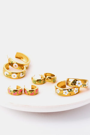 Gold hoop earrings with floral enamel details in pink, white, and green.