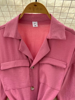 Pink belted wide-leg maternity jumpsuit with buttoned chest pockets and collar.