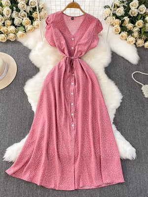Pink polka dot maxi dress with v-neck, short sleeves, button front and tie belt.