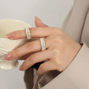 Gold baguette eternity band ring with clear stones on a woman's hand