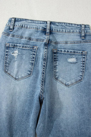 Distressed light wash denim flare jeans with open knee detail.