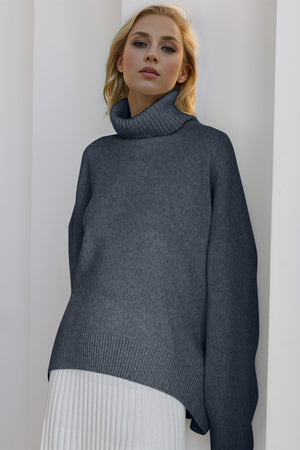 Oversized dark gray cashmere turtleneck sweater with ribbed details and a cocoon cut.