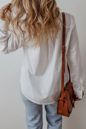 White cotton button-up shirt with eyelet ruffle detail, casual long sleeves.