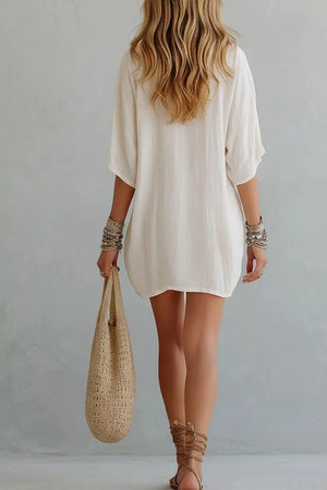Relaxed white mini dress with half sleeves and V-neck, shown from the back.