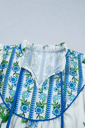 White polyester shirt with blue floral print, tie-neck, and ruffled collar.