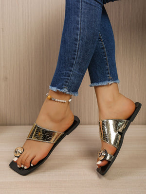 Gold square toe ring sandals with asymmetric strap and embossed texture.