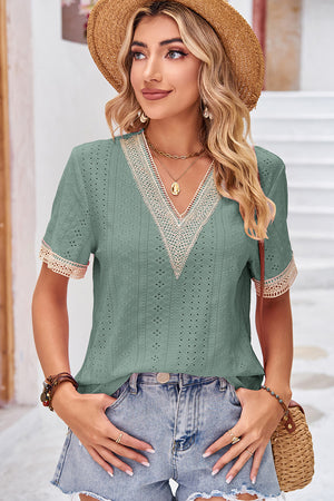 Sage eyelet v-neck blouse with lace trim and short sleeves.