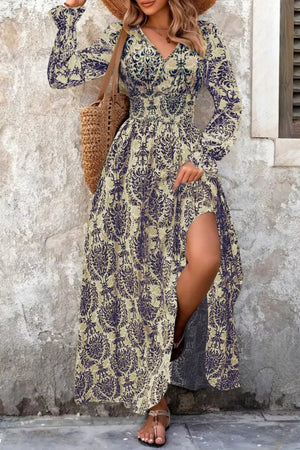 Maxi dress with bishop sleeves, cinched waist, and high slit in a navy and sage print.