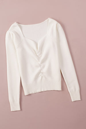 Ivory ribbed knit sweater with sweetheart neckline and ruched front detail.