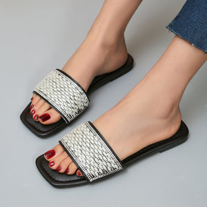 Black open toe slides with pearl and rhinestone embellished straps.